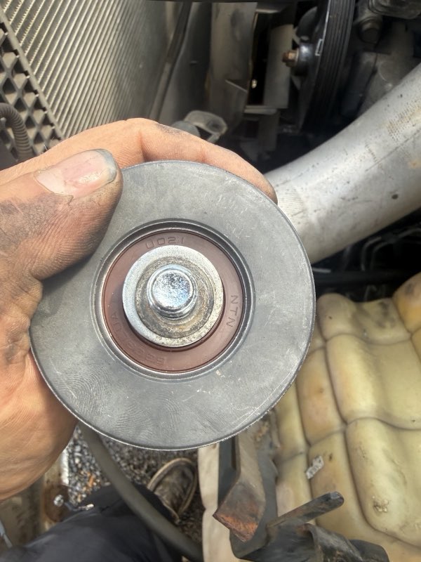 Replacement pulley and bearing held during a repair