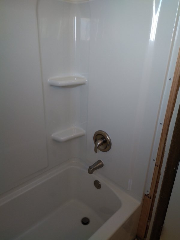 New bathtub and shower surround with fixtures