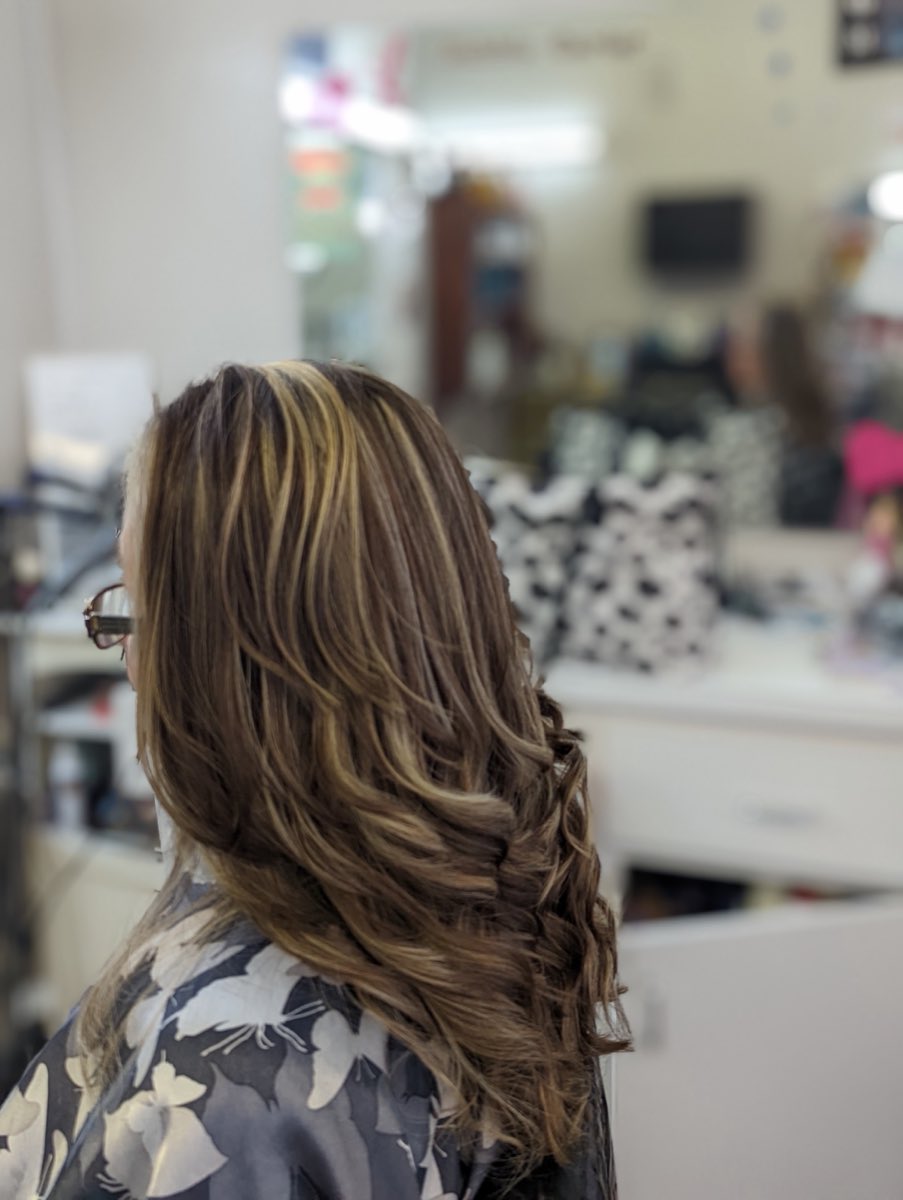 Glossy highlights and soft curls styled on a client at Bold En' Beautiful Salon