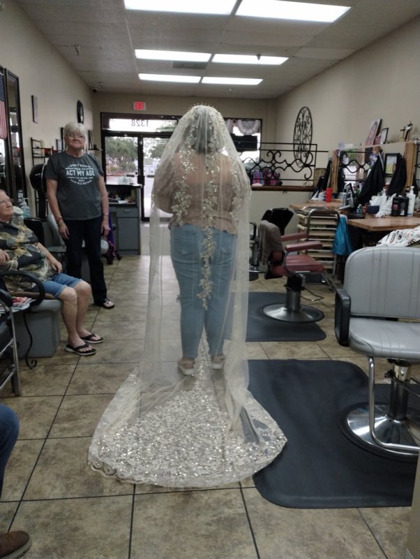 A bride in a long beaded lace veil styled at Bold En' Beautiful Salon