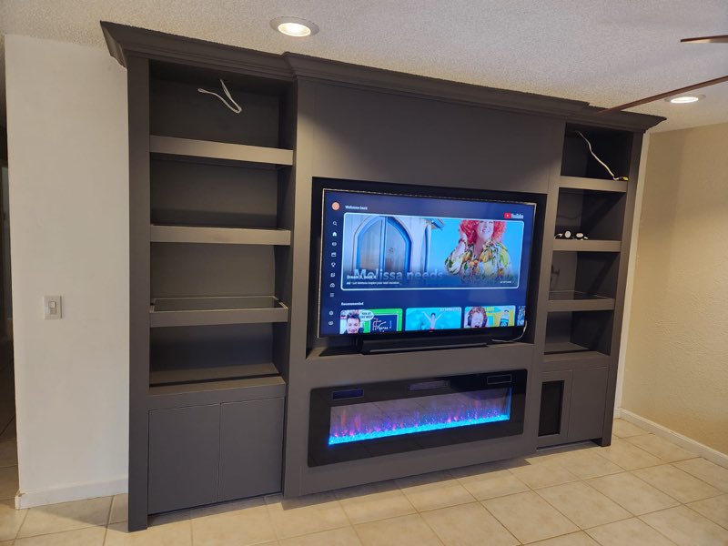 Custom built-in entertainment center with shelving and an electric fireplace