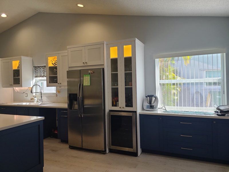 Kitchen with navy base cabinets and glass-front display cabinetry