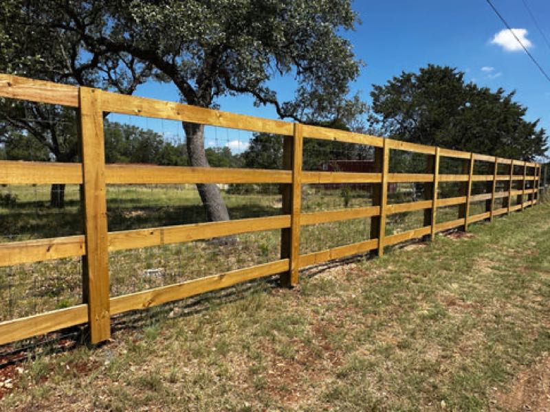 Split-rail wood fence running the length of a green property
