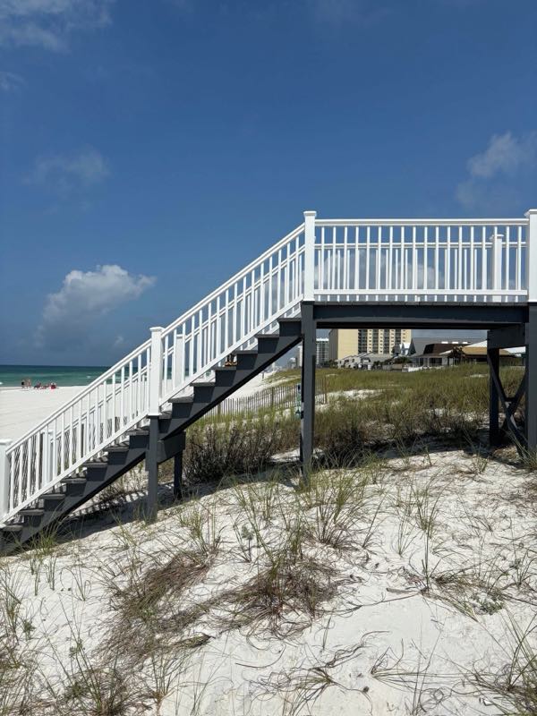 Custom white deck and staircase leading over the dunes to a Gulf Coast beach
