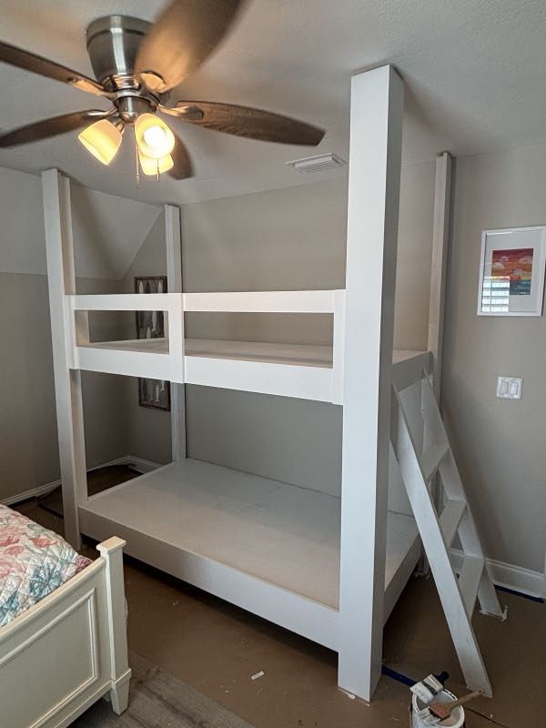 Custom-built white bunk bed with a ladder, built on site in a bedroom