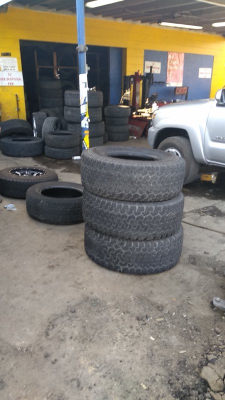 Stacks of tires and a truck inside the Corner Tires service bay