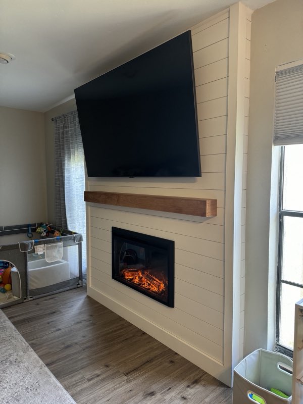 Shiplap fireplace feature wall with a floating wood mantel