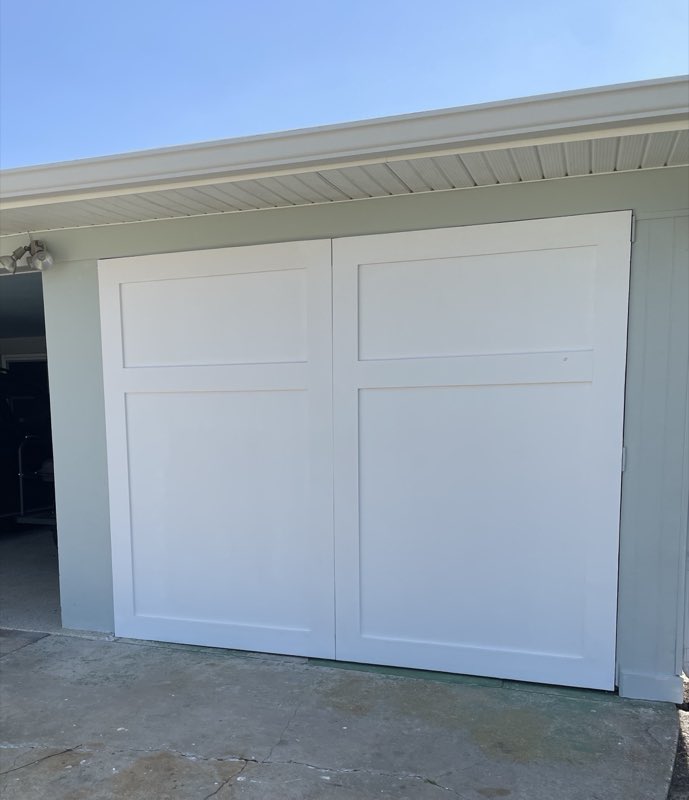 Custom-built white sliding doors on a garage opening
