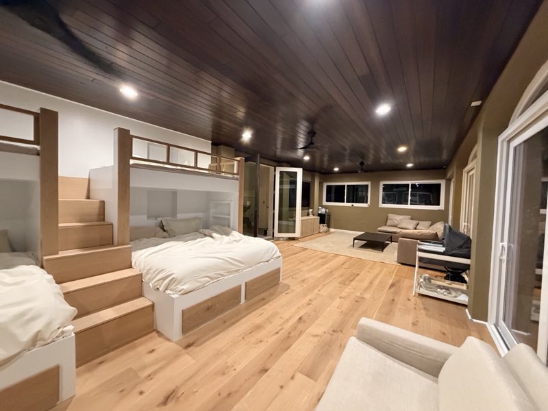 Bedroom with platform bed, loft bunk, and custom wood plank ceiling