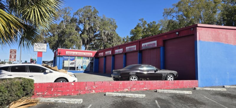 Florida Tires red and blue building from the street with the A/C Repair bay sign