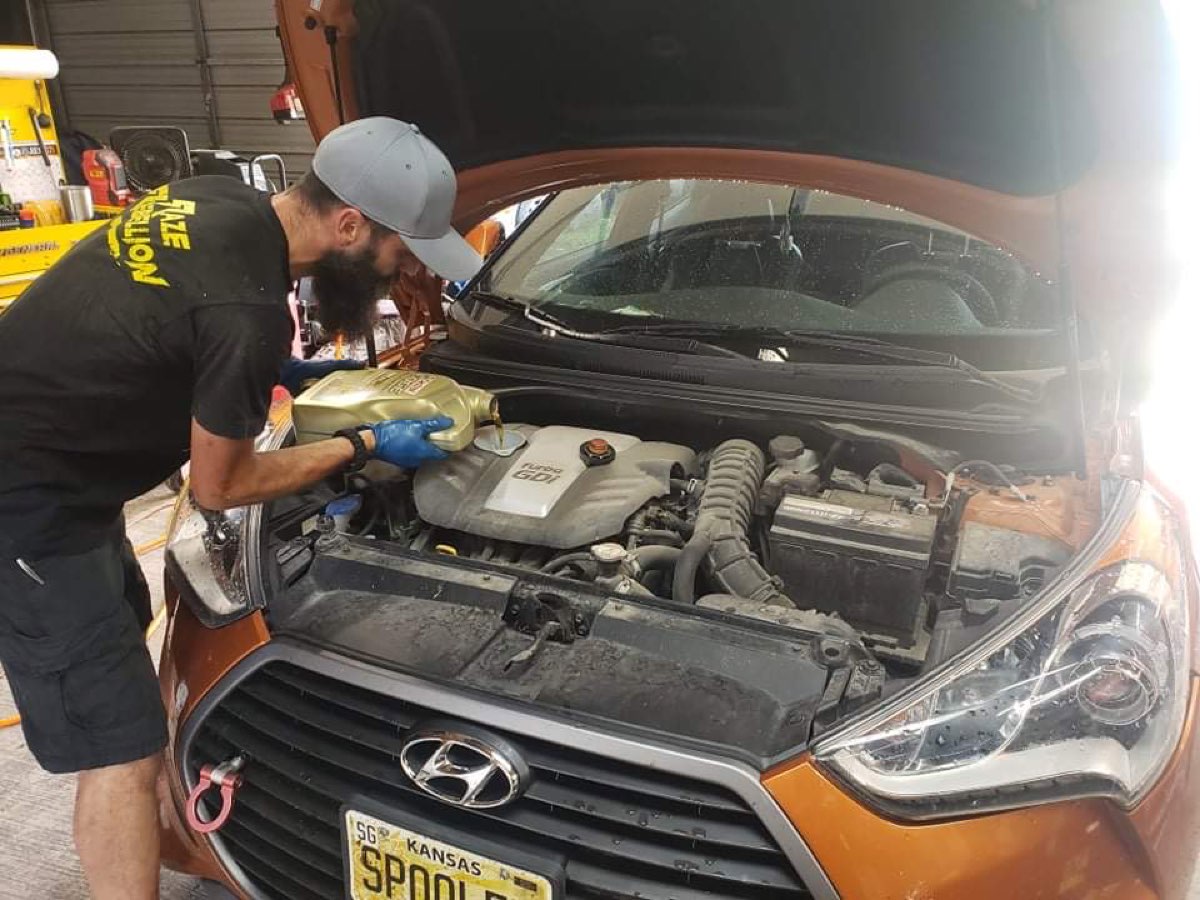A Full Send Garage technician changing the oil on a turbocharged Hyundai in the shop