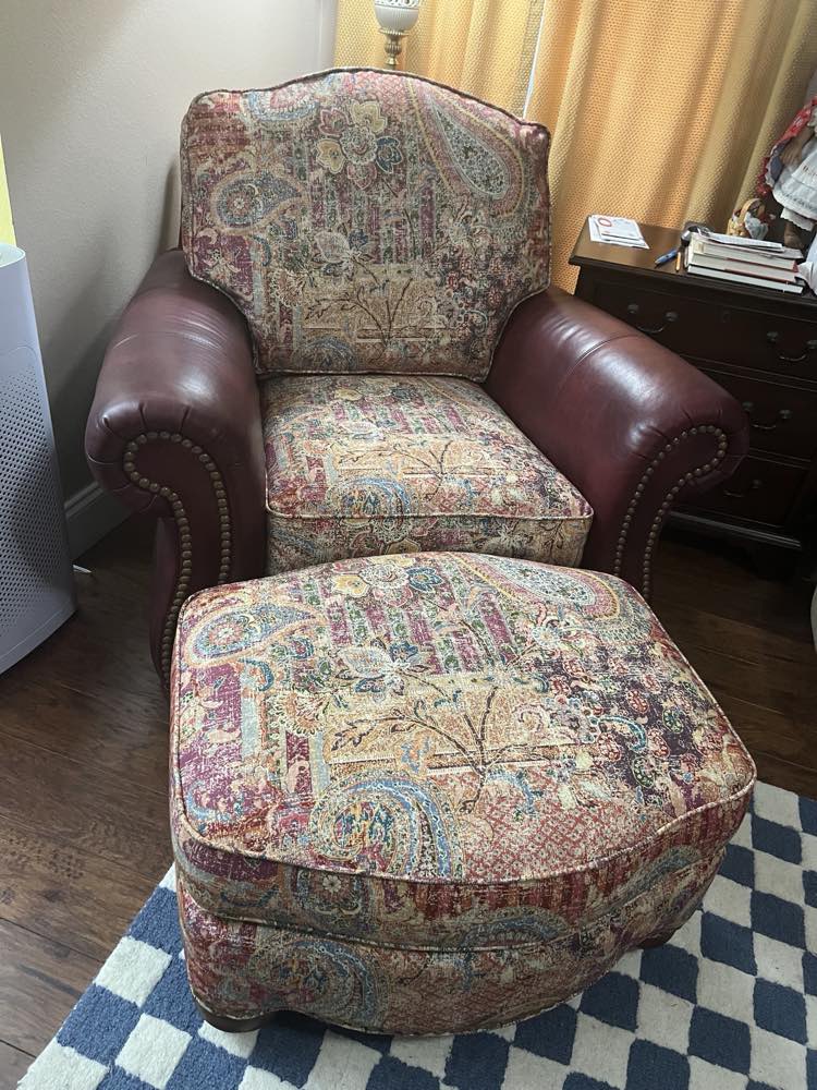 Reupholstered tapestry armchair with matching ottoman in a rich paisley fabric and burgundy leather arms