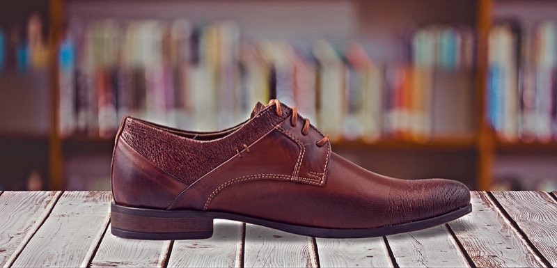 A polished brown leather dress shoe, the finished result of a repair