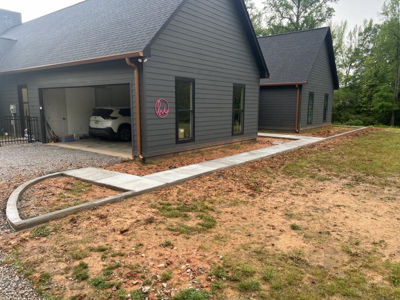 Modern gray home with a freshly poured curved concrete driveway and walkway