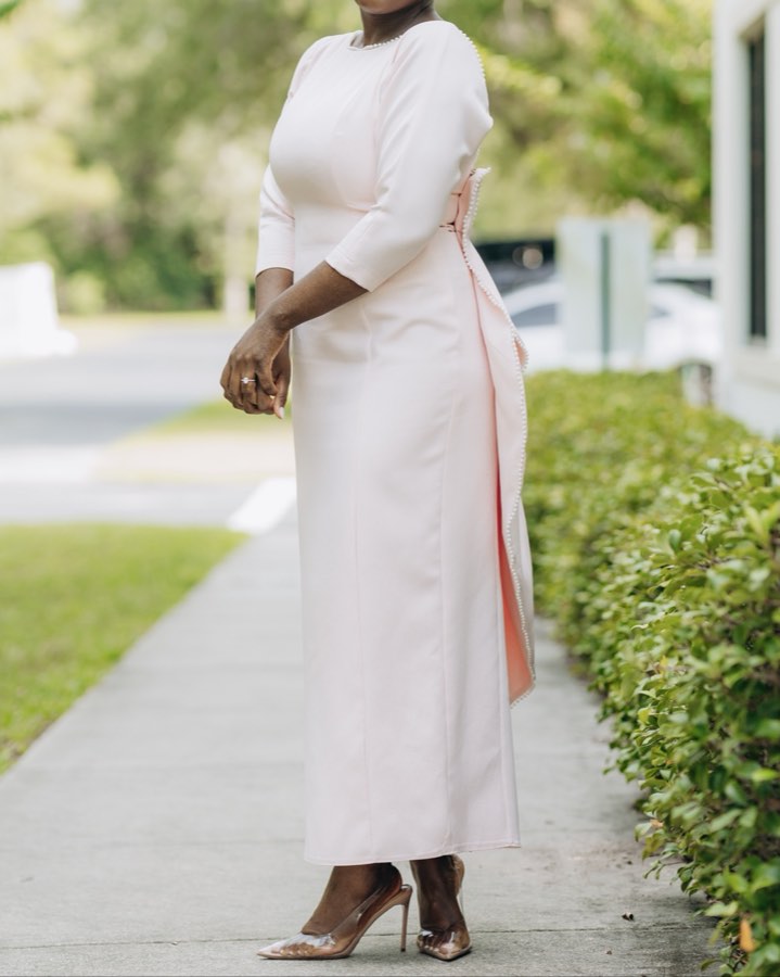 Client in an elegant pearl-trimmed dress photographed outdoors