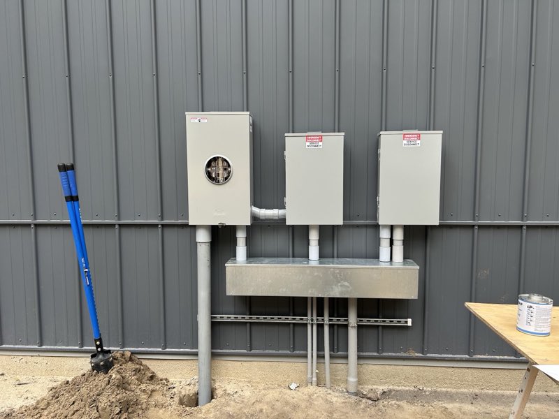 Clean triple meter and service-disconnect installation on a metal building