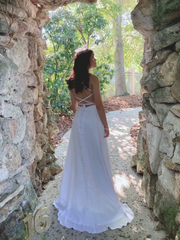 Client photographed from behind in a backless white gown in a stone archway