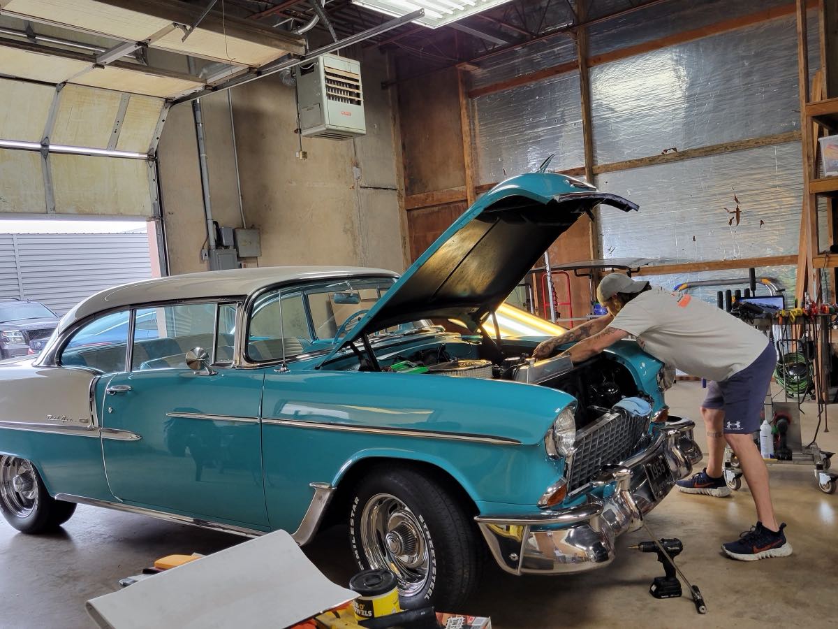 A classic teal Chevrolet Bel Air being worked on inside the PDR Plus Inc shop