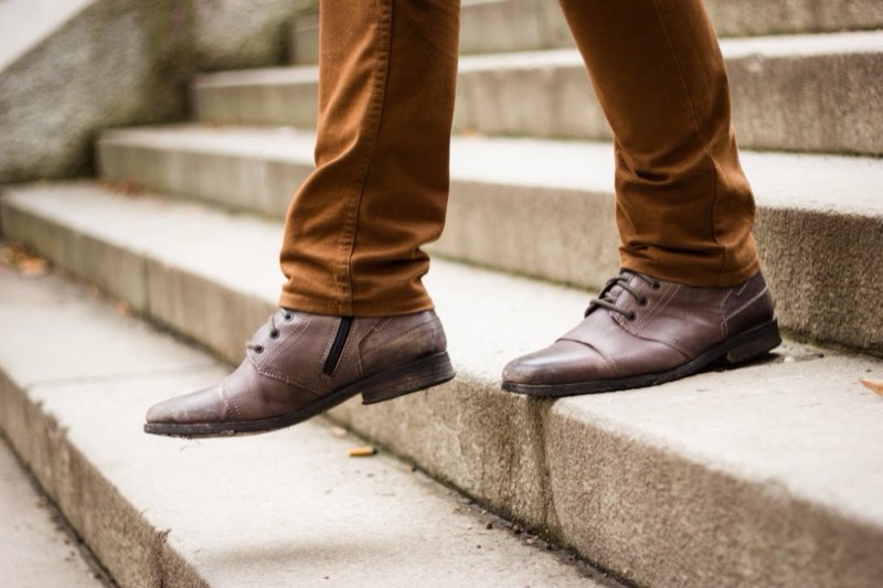 Polished brown leather boots on stone steps