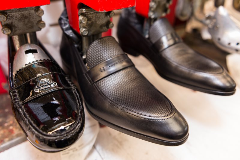 Shined black dress shoes on shoe stretchers in the workshop