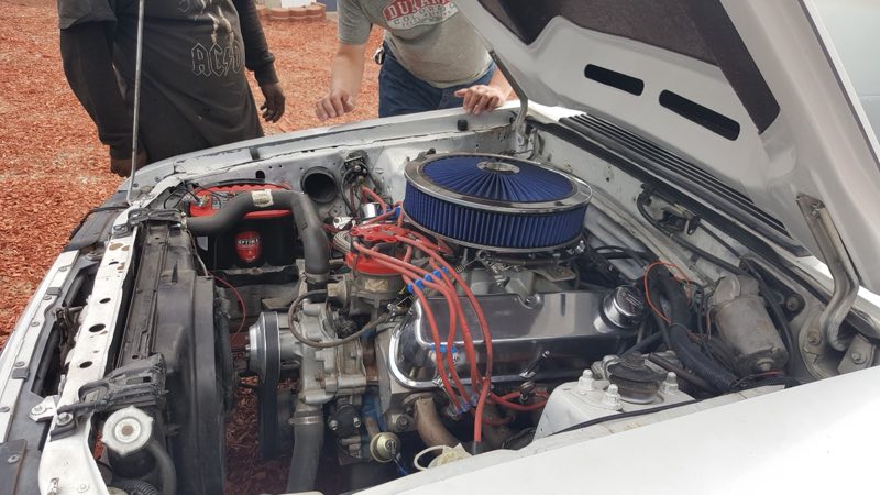 V8 engine bay being worked on, chrome air cleaner and new red plug wires